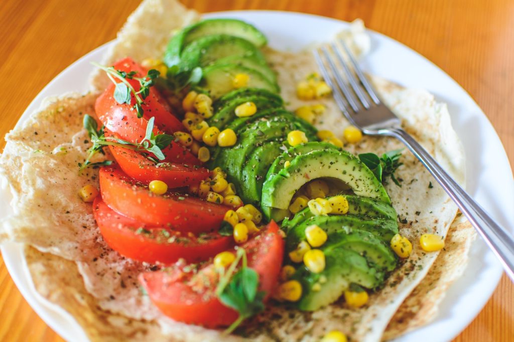 assiette végétarienne colorée avec toast avocat tomate mais voyage ecolo