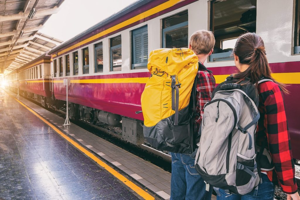 femme et homme gare qui attendent le train voyage et environnement